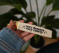 a person holding a keychain that says very demure, very quiesy