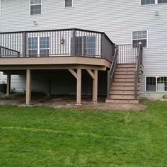 a house with a deck and stairs in the grass