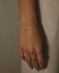 a woman's hand with a small tattoo on it