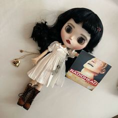 a doll is laying on the floor next to a book