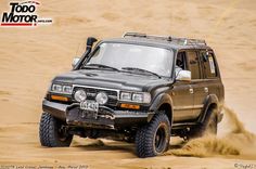 an suv driving through the sand in the desert