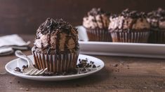 chocolate cupcakes with frosting and sprinkles on a white plate