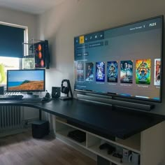 a computer desk with two monitors and a keyboard in front of a large screen monitor