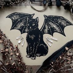 a bat sticker sitting on top of a piece of paper next to some branches