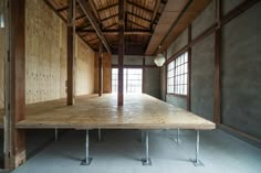 an empty room with wooden flooring and exposed ceiling, in the middle of a building