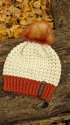 a white and orange knitted hat with a pom - pom on top