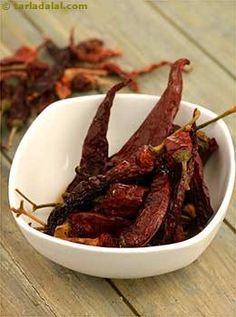 dried red peppers in a white bowl on a wooden table