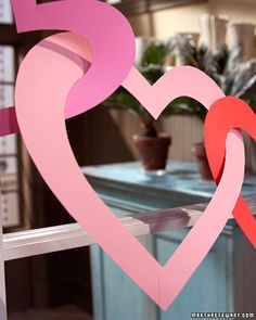 a pink heart cut out of paper sitting on top of a window sill