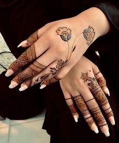 two hands with henna tattoos on them