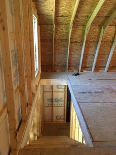 an unfinished attic with wooden walls and windows