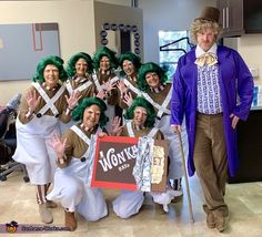 a group of people dressed in costumes posing for a photo with a sign that says work out