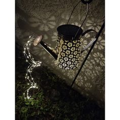 a watering can is lit up in the dark