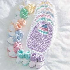 crocheted baby booties and bibs laid out on a bed