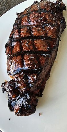 a piece of steak sitting on top of a white plate