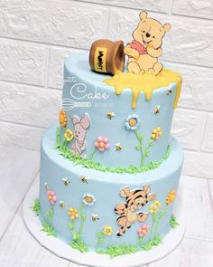 a winnie the pooh birthday cake with honey on top and fondant decorations around it