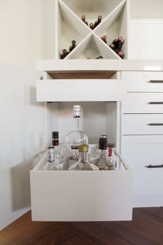 an open cabinet with liquor bottles in it