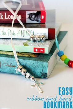 three books stacked on top of each other with a bead necklace attached to them