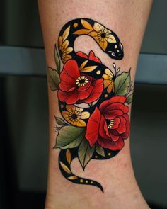 a snake and flowers tattoo on the leg