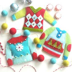 some felt ornaments are laying out on the table next to candy canes and candies