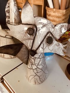 an elephant sculpture sitting on top of a table next to some utensils and other items