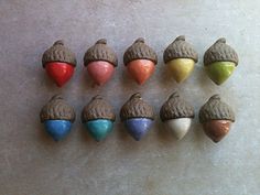 nine different colored acorns are lined up in a row on a table top