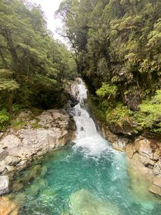 a small waterfall in the middle of a forest