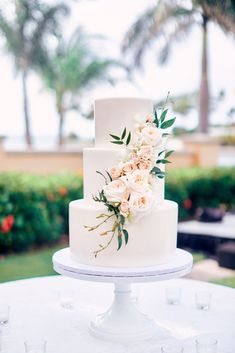 a white wedding cake with flowers on top