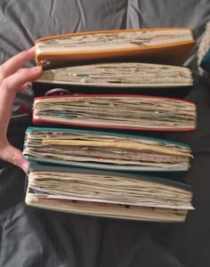 a person is holding several books in their hands