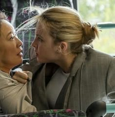 two women sitting next to each other on a bus