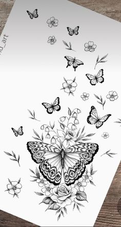 a card with butterflies flying around it on a wooden table next to a pen and ink