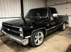 an old black truck parked in a garage