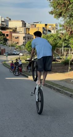 a man riding a bike down the middle of a street