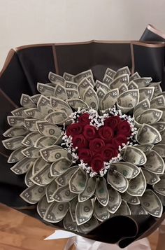 a heart shaped arrangement made out of dollar bills