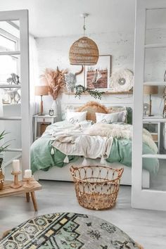 a white bedroom with wicker furniture and baskets hanging from the ceiling over the bed