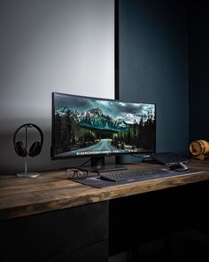 a desktop computer sitting on top of a wooden desk next to a mouse and headphones