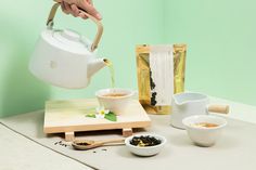 a person pouring tea into small white bowls