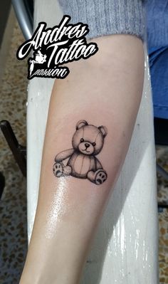 a small teddy bear tattoo on the arm