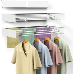 several shirts hanging on a rack in front of a white wall