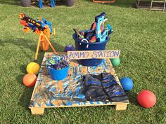 an assortment of toys sitting on top of a wooden crate in the grass next to balls