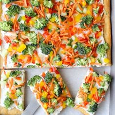 broccoli, carrots, and cheese pizza on a baking sheet