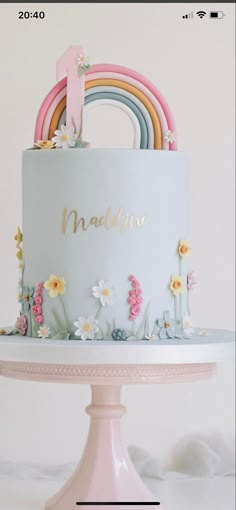 there is a cake with flowers and a rainbow on the top, which reads naddivine