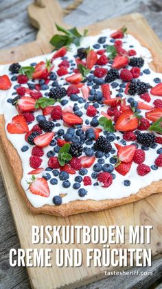 a dessert with berries, strawberries and yogurt is on a cutting board