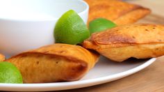 limes and pastries on a plate next to a cup