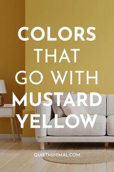 a white couch sitting on top of a hard wood floor next to a yellow wall