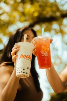 a woman holding up a drink in front of her face with the word pooh on it