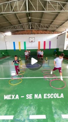 children are playing with hoop rings in an indoor gym