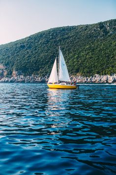 a small sailboat floating on top of a large body of water