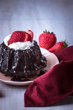 a chocolate cake with whipped cream and strawberries on the side, ready to be eaten