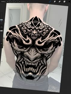 the back of a man's body with an intricate tattoo design on his chest