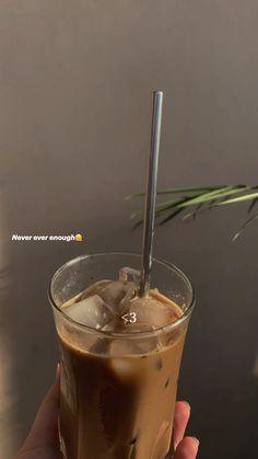 a hand holding a drink with a straw in it